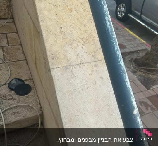 מעקה מתכת עם צבע מתקלף על מדרגות אבן